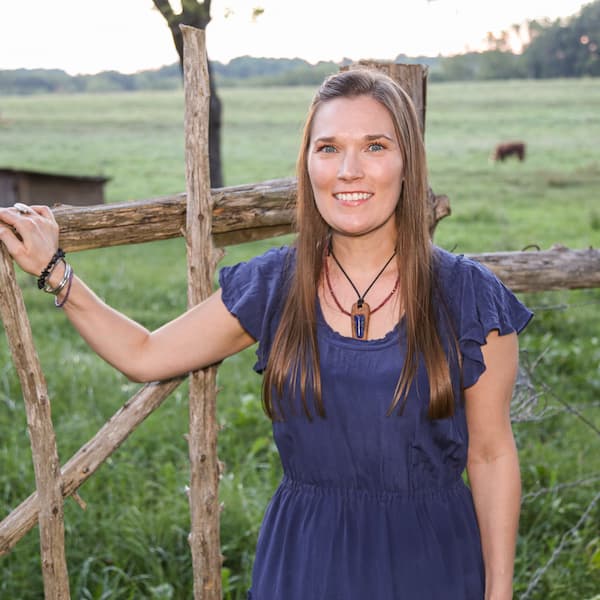 Lucy McPherson standing next to a wood fence